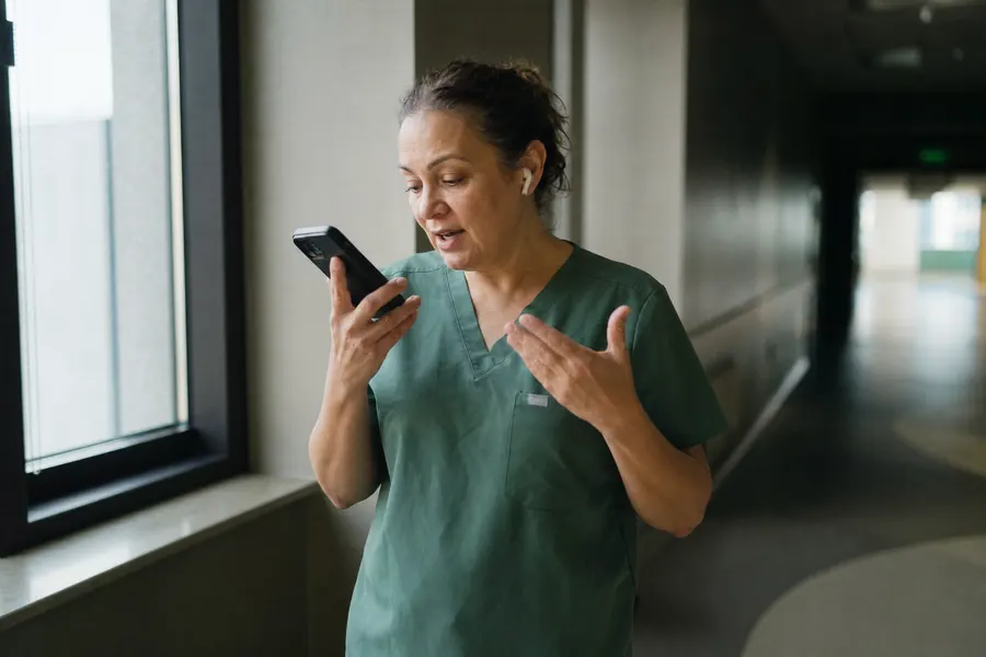 A nurse on her break answering a follow-up question on her phone