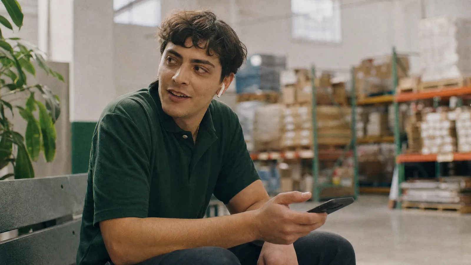 A warehouse worker on his break answering interview questions on his phone